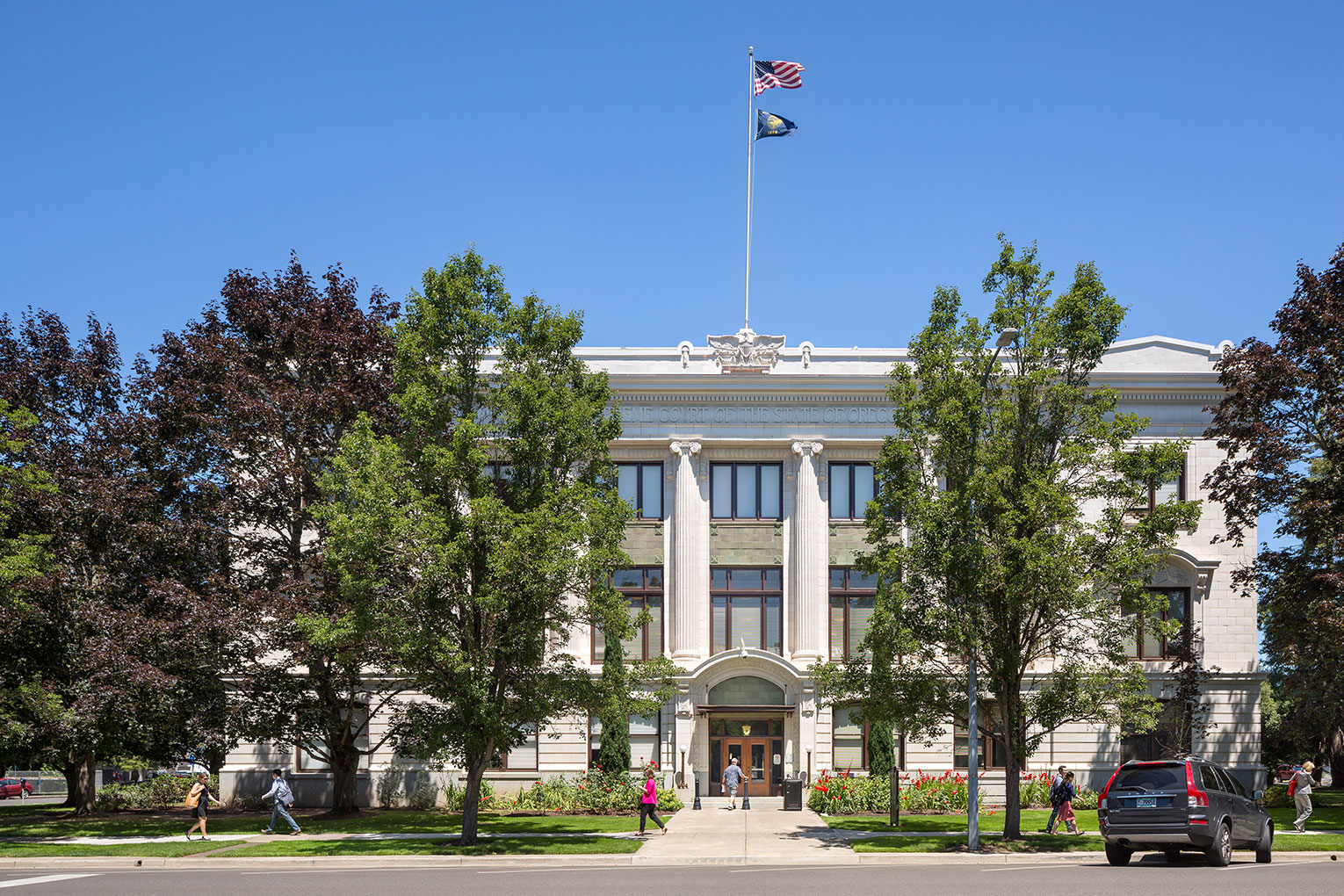 Exterior image of a large colonial-style Oregon Supreme Court Building clad in cream-colored terra cotta with five ornate columns in relief on the front of the building's facade.