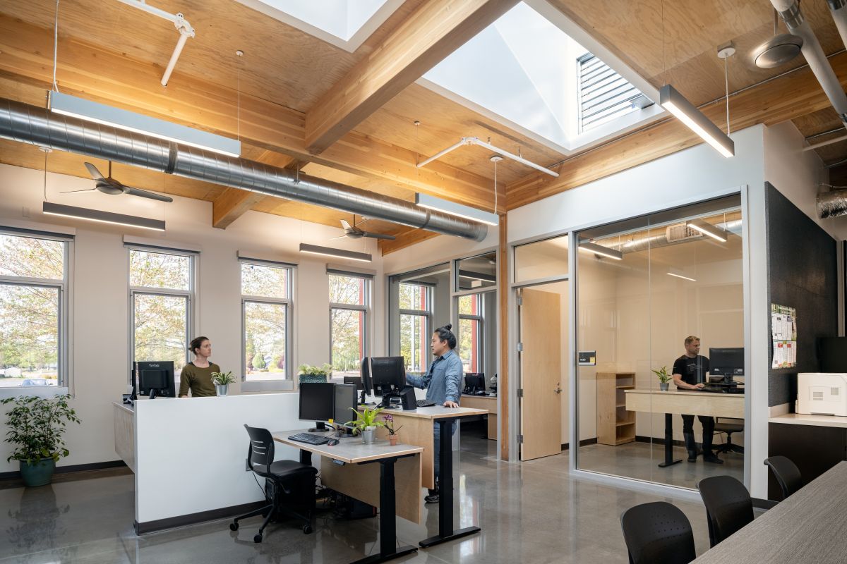 Staff work beneath skylights in the Chemeketa Agriculture Complex, where exposed mass timber and interior glazing bring daylight deep into the office.