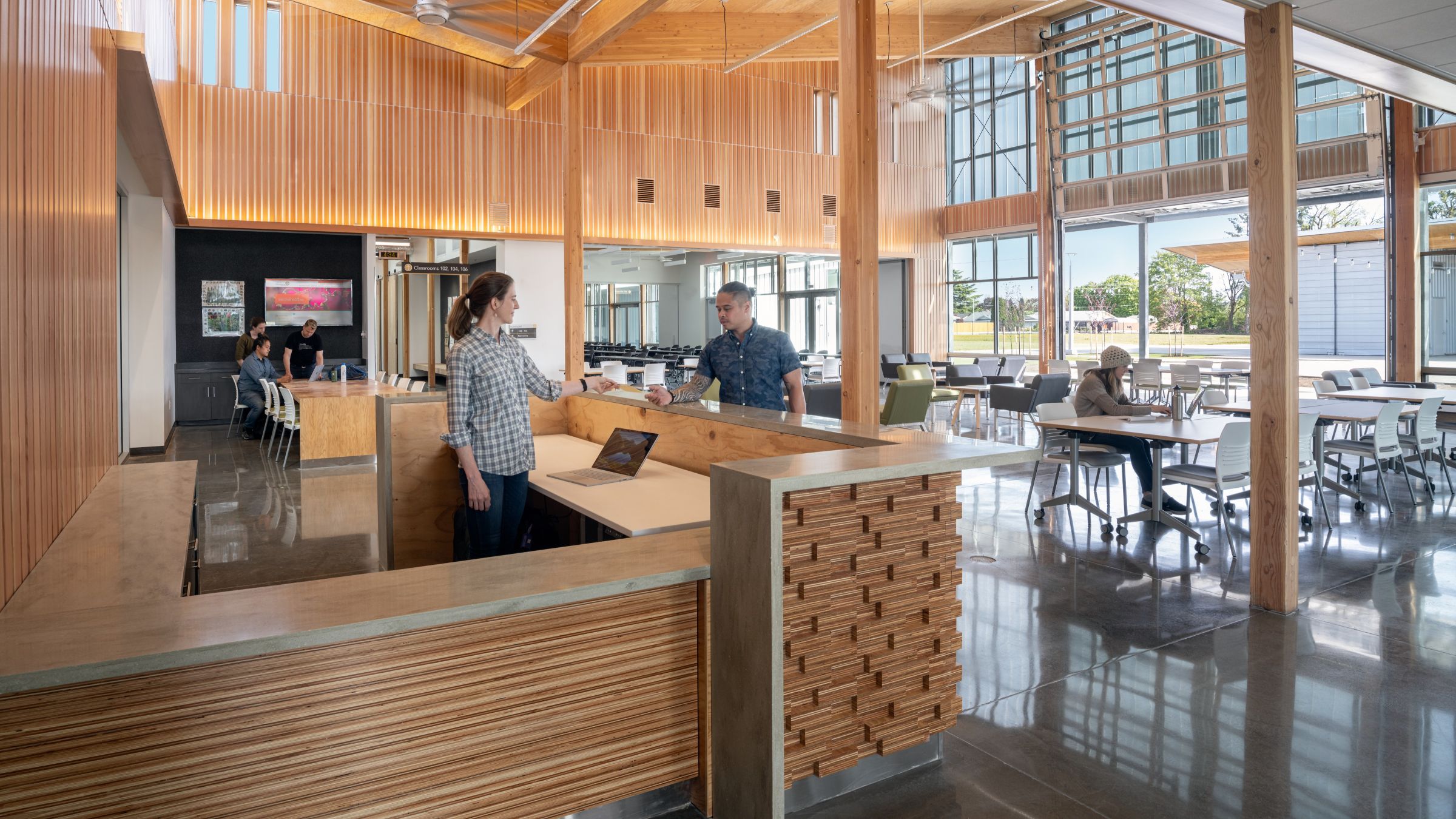 Students gather and work in the Chemeketa Agriculture Complex lobby, where mass timber, flexible seating, and large operable doors support collaborative learning.