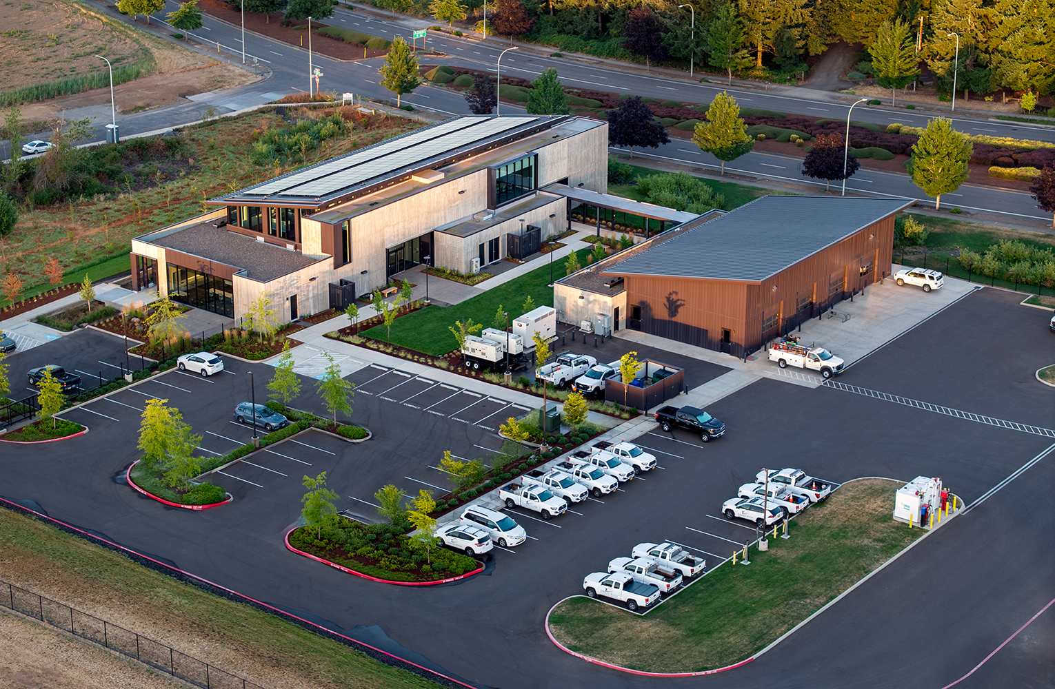 An aerial view of Sunrise Water Authority’s new campus showing the administrative building, shop, landscaped courtyard, and fleet parking arranged along restored site plantings and adjacent roadways.