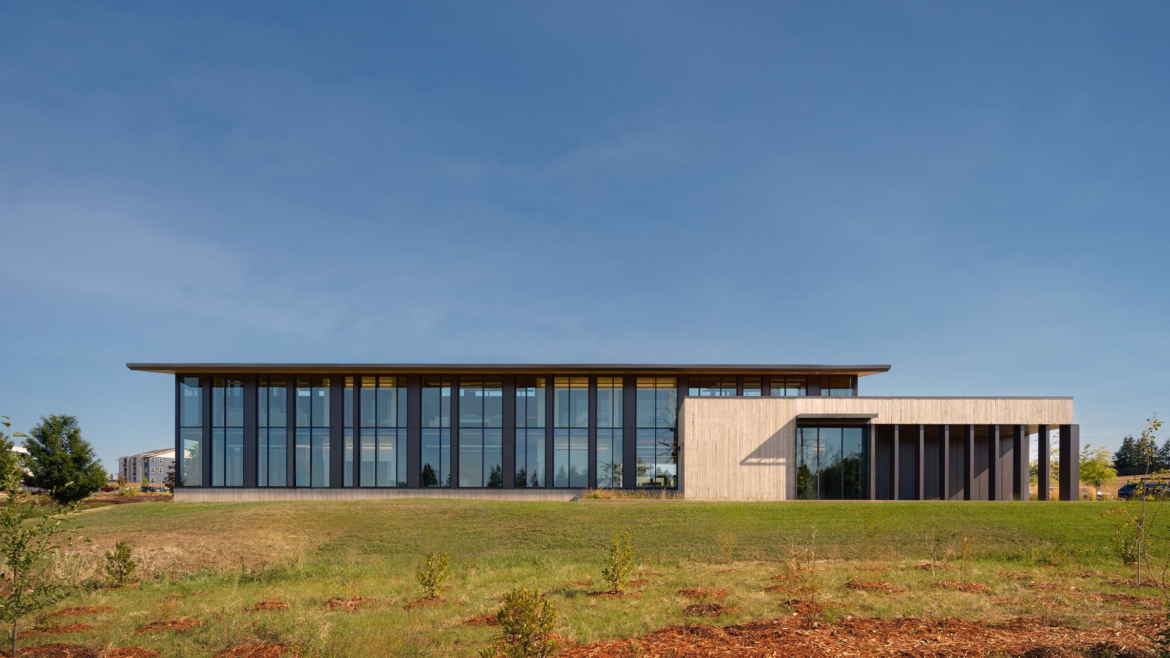 Sunrise Water Authority’s headquarters presents a long glazed façade, deep roof overhangs, and a restrained material palette within a landscaped campus setting.