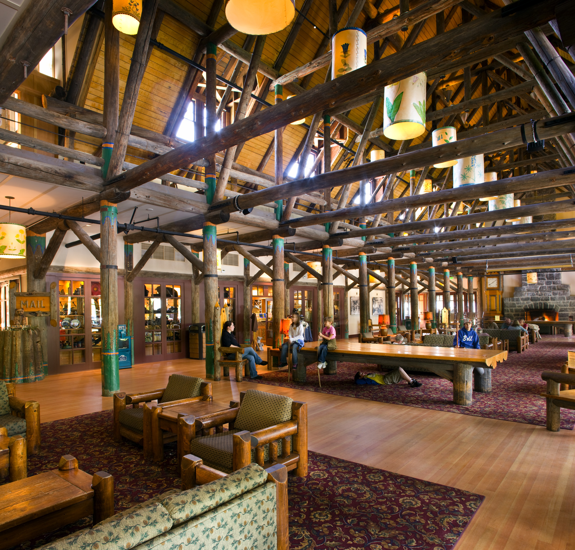interior lobby of the Mt. Rainer Lodge. Large beams exposed revealing an expansive roof. Lobby is filled with comfortable seating and happy guests
