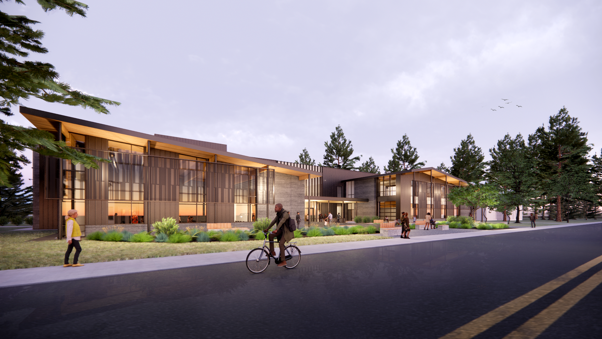 Dusk exterior of a new community center with people walking and biking by