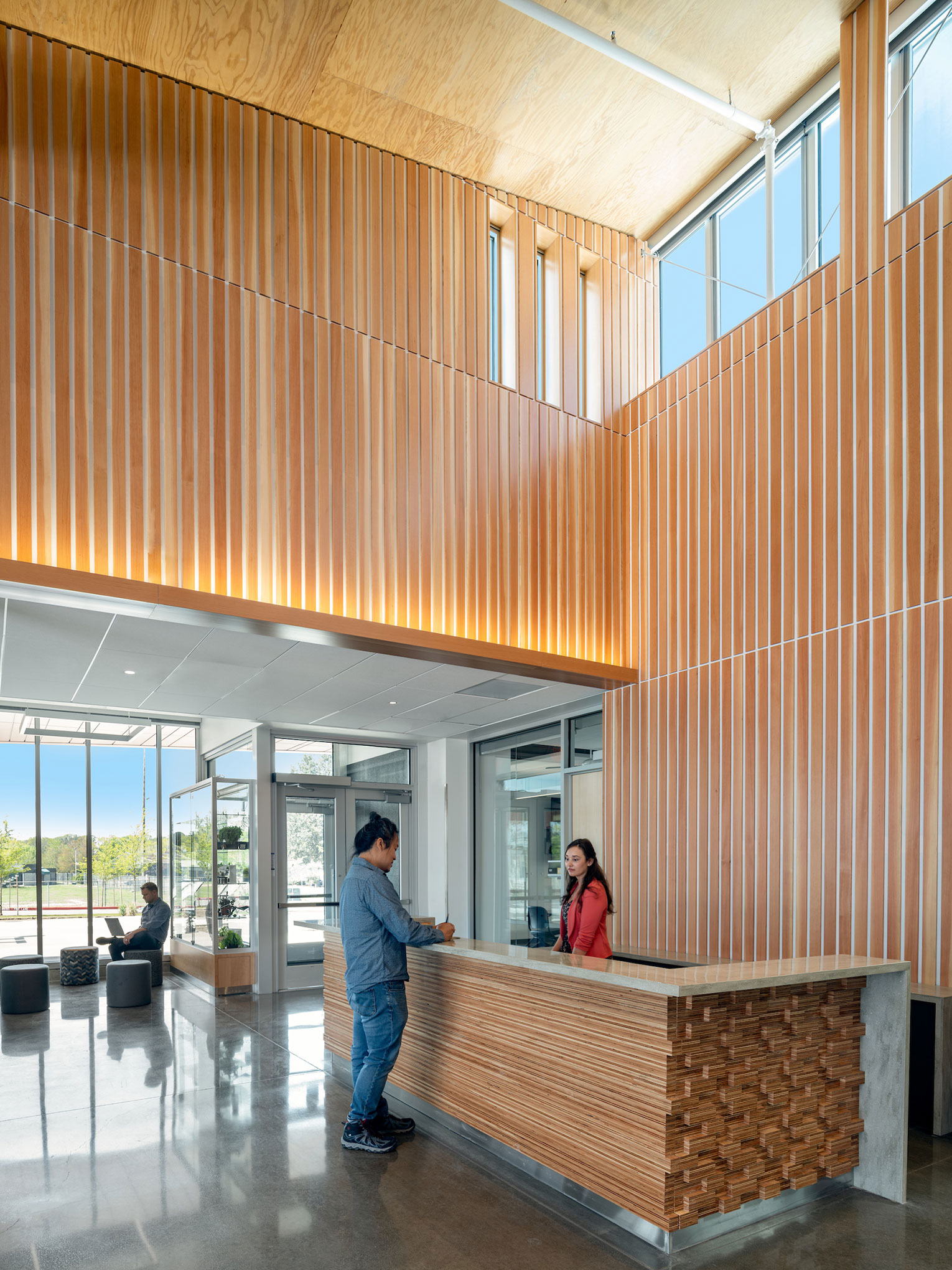 Man standing at entry desk, taking to receptionist