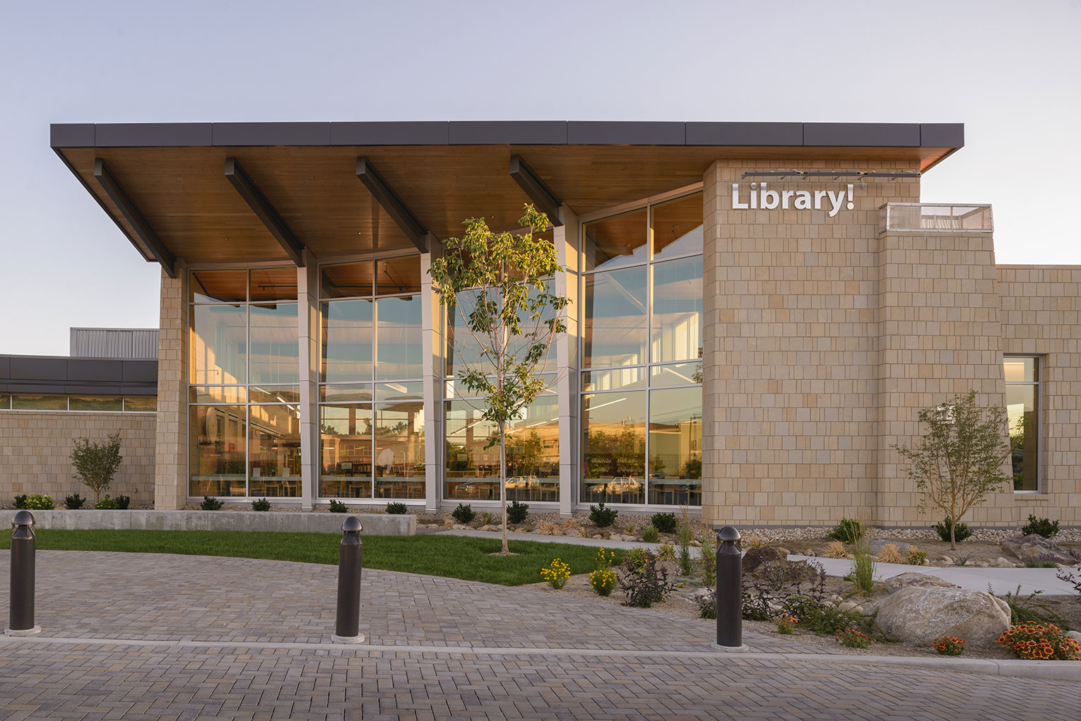 Exterior view of floor to ceiling library windows just as the sun starts to set