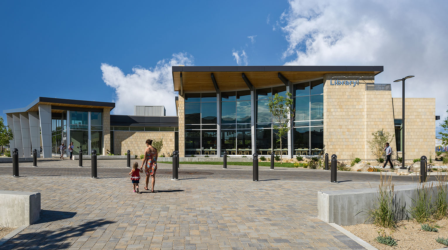 Mother and child walking across plaza toward library