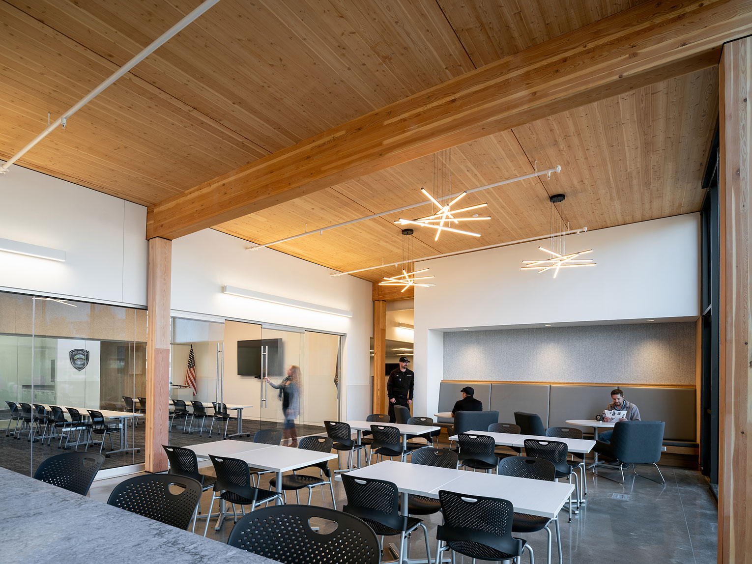 Staff breakroom with tables and chairs, people relaxing