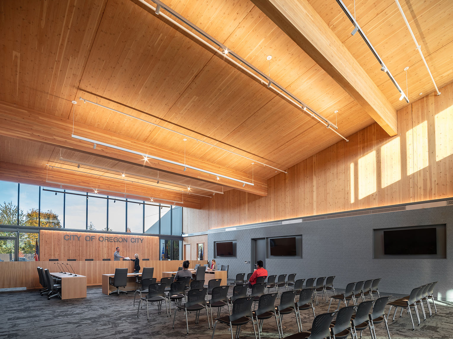 Large, daylit courtroom/council chambers with mass timber ceiling and walls