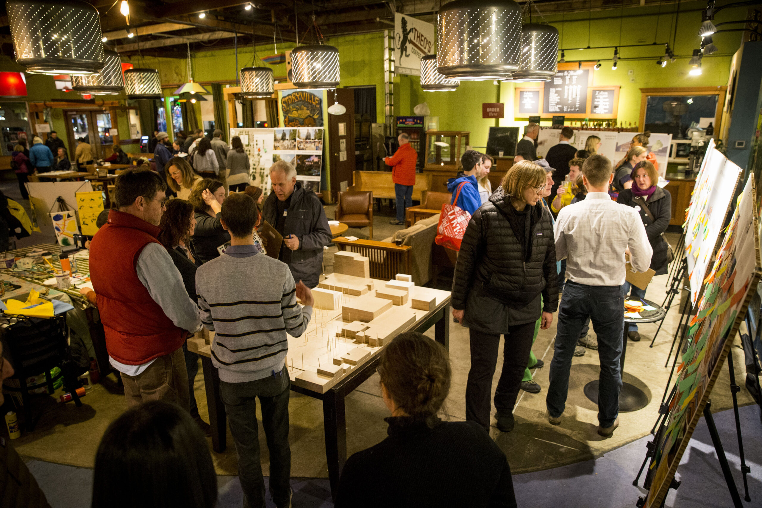 Members of the public milling around an open house learning about and providing feedback for a future library project.