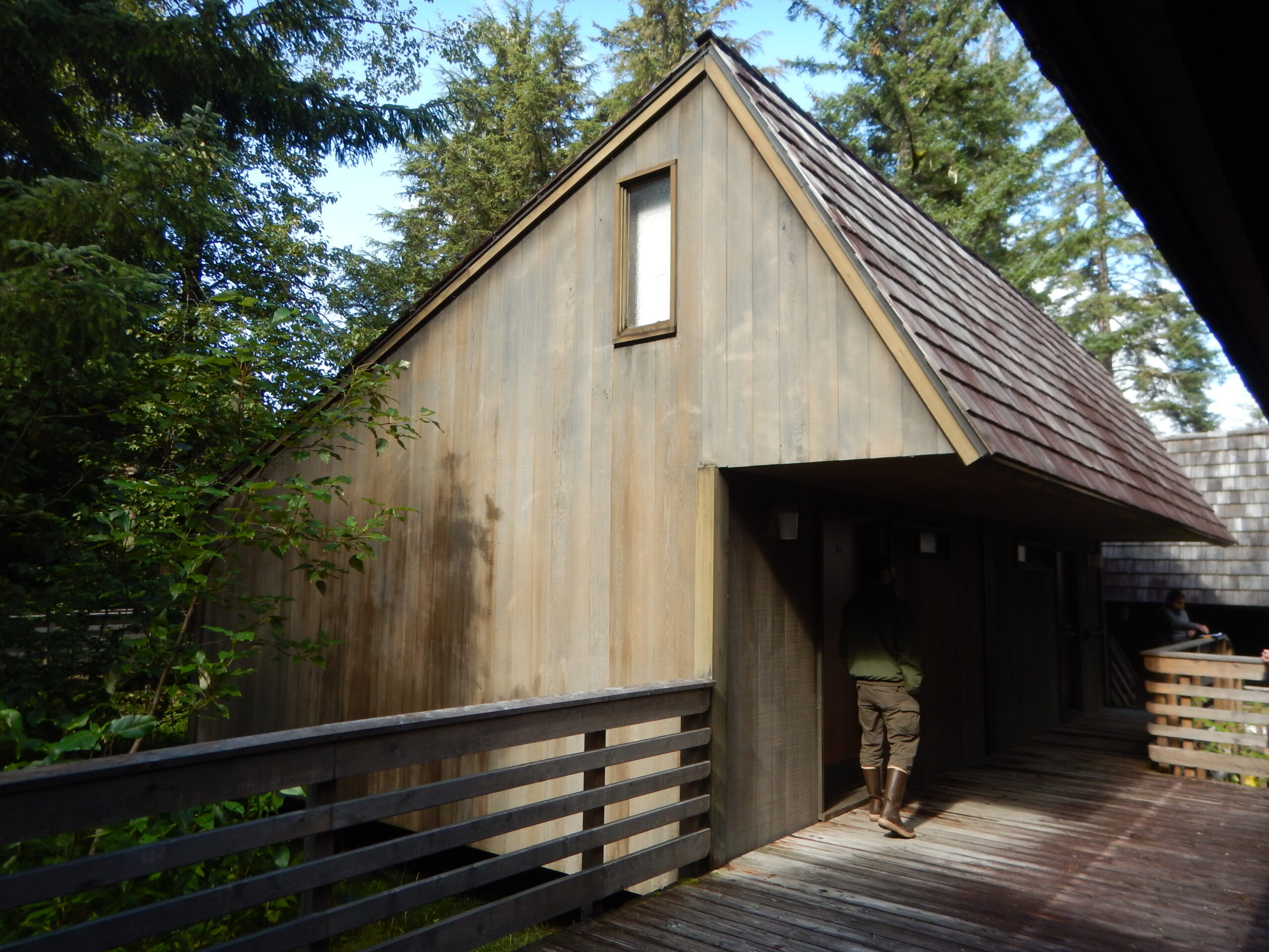 The exterior of a small wooden cabin and boardwalk