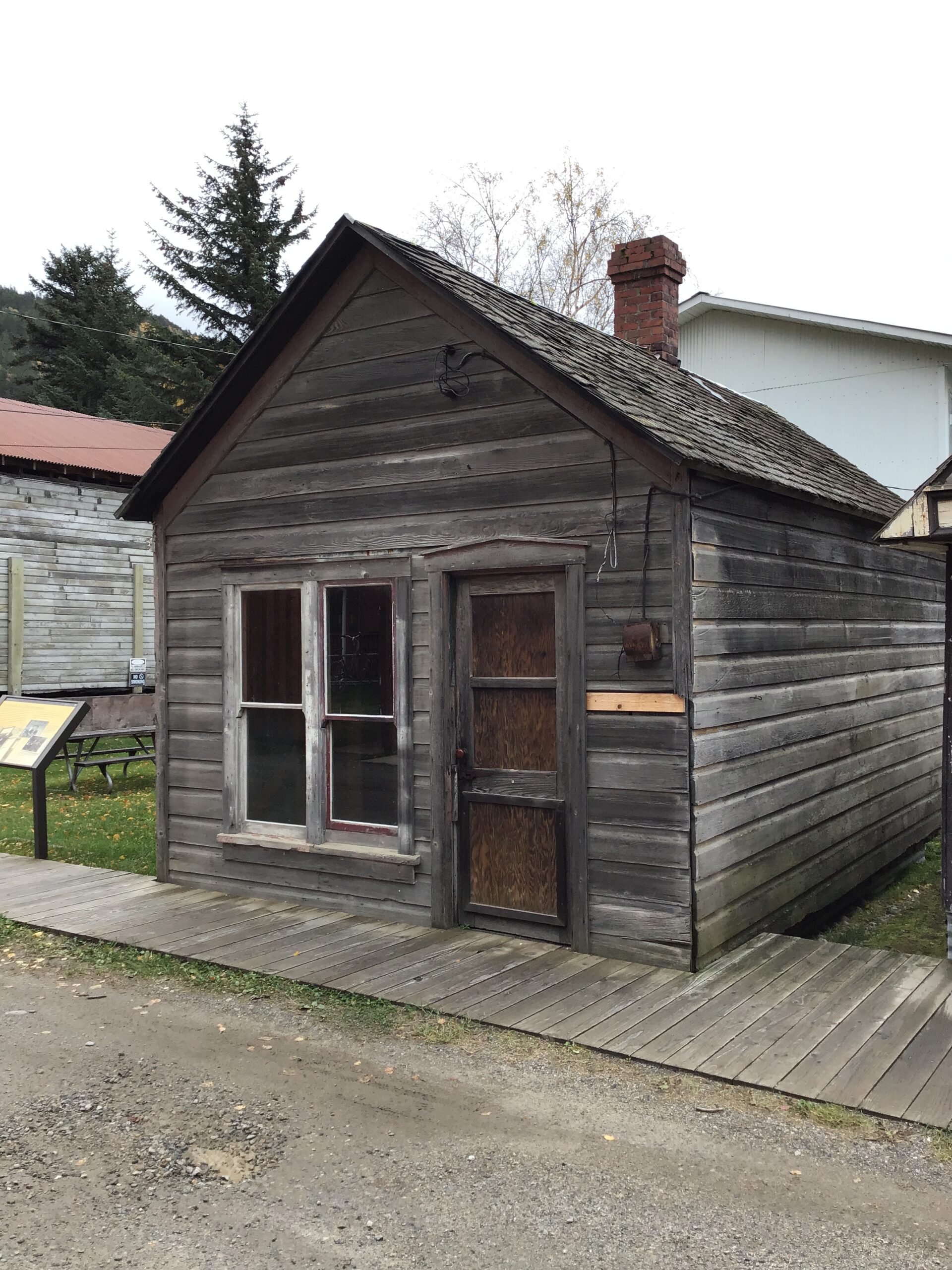A small, old shack-type building fronted by a boardwalk