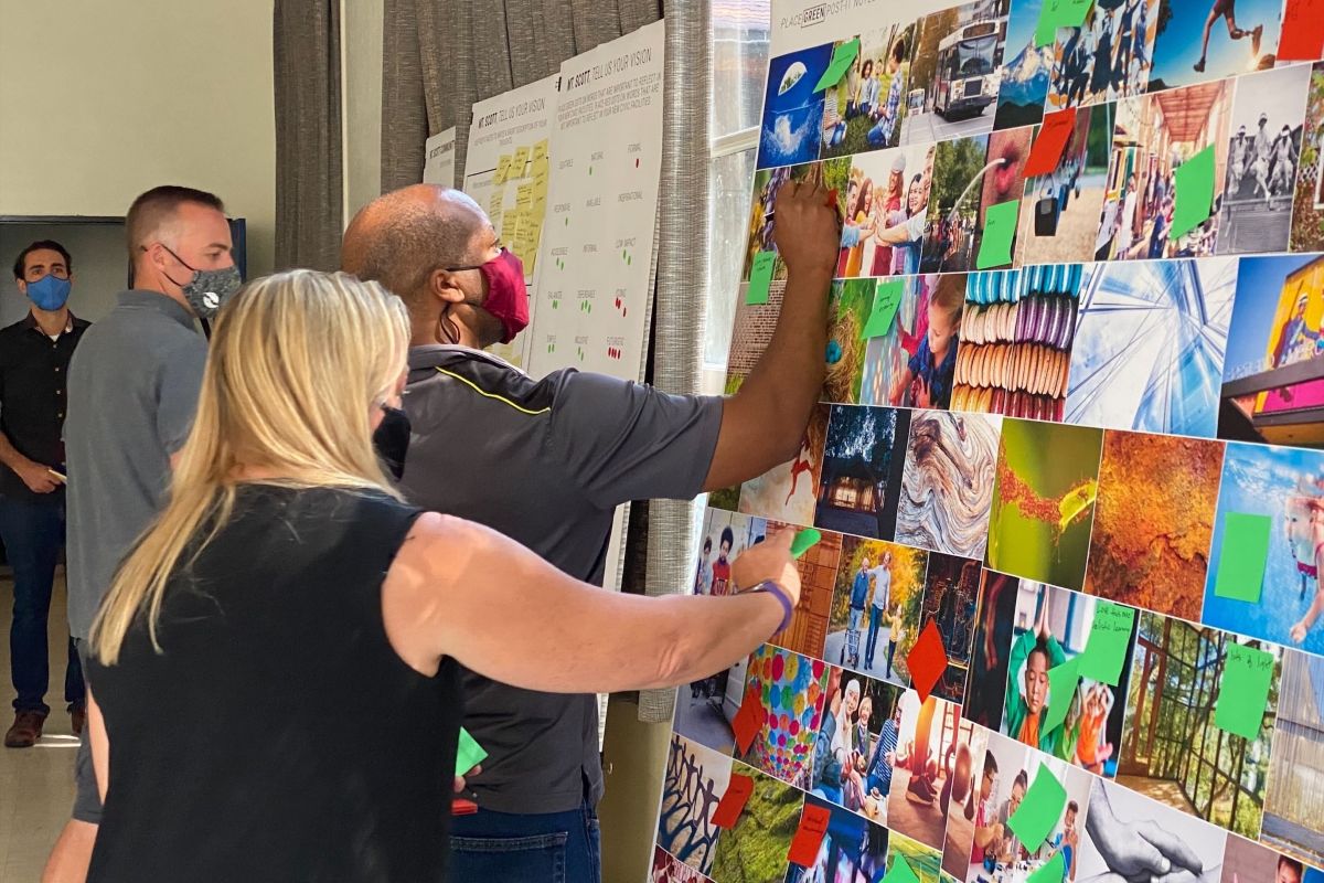 Community members place feedback on an image-based vision board during early engagement for the Mt. Scott Community Center renovation.