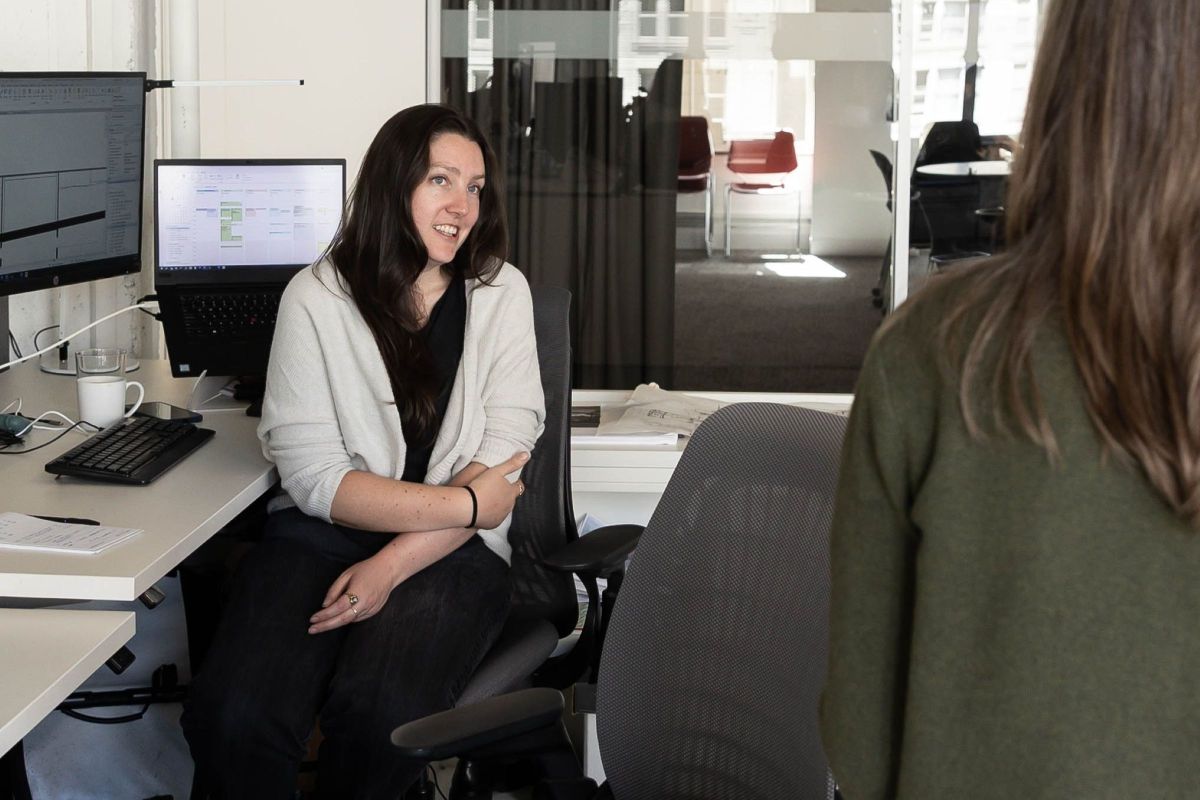 Two FFA team members discuss project work at a workstation in the firm’s open architecture studio
