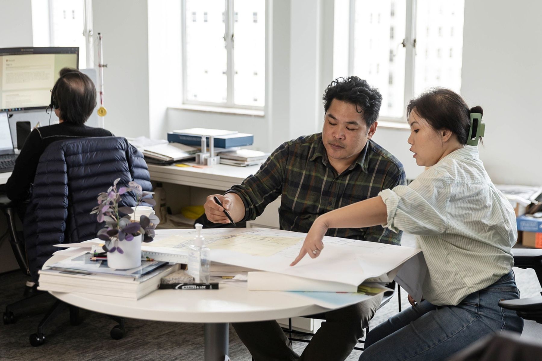 Two FFA architects review and mark up drawings together during a collaborative mentoring session in the studio.