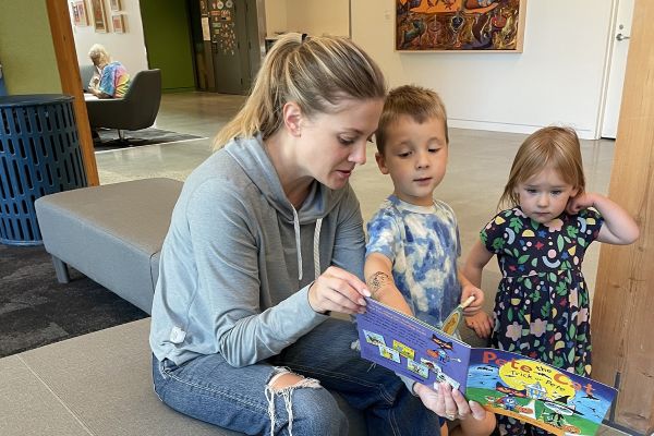 A parent reads with two young children in a flexible seating area at Mt. Scott Community Center.