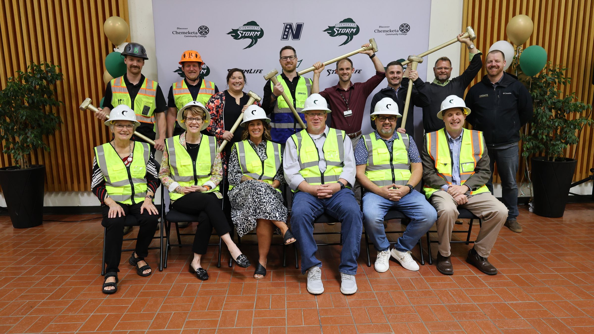 Project partners celebrate the Chemeketa Athletic Center groundbreaking, wearing hard hats and safety vests while posing with ceremonial sledgehammers.