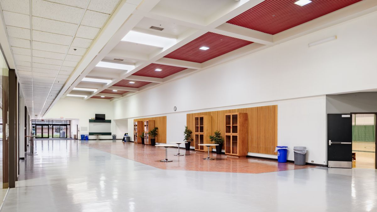 Existing lobby at the Chemeketa Athletic Center before renovation, showing a wide circulation area with limited seating and dated finishes.